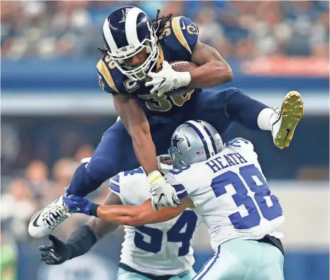  ?? TIM HEITMAN, USA TODAY SPORTS ?? Rams running back Todd Gurley hurdles Cowboys safety Jeff Heath en route to 121 yards rushing and a 53-yard TD reception.