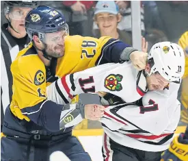  ??  ?? Nashville’s Paul Gaustad, left, fights with Chicago’s Andrew Desjardins.