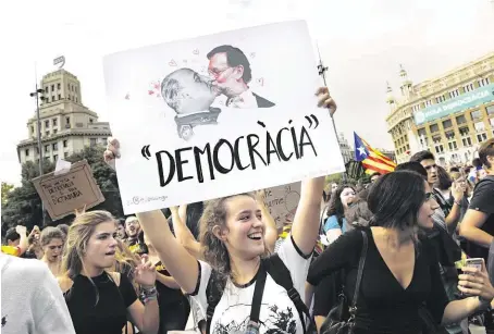  ?? Demonstruj­ící dívky v centru Barcelony vystavily i karikaturu, na které španělský premiér Rajoy líbá diktátora Franka. FOTO REUTERS ?? Demokracie trpí.