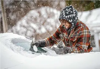  ?? Dan Busey/Associated Press ?? Daniel Cole uses a plastic spoon to clear ice from his vehicle Monday in downtown Florence, Ala. About 150 million Americans were under a wind chill warning or advisory.