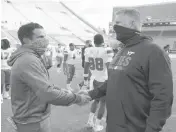  ?? MATT GENTRY | THE ROANOKE ?? Hurricanes coach Manny Diaz, left, and Virginia Tech coach Justin Fuente meet at midfield.