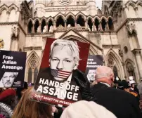  ?? — AP ?? A demonstrat­or holds a placard, after Stella Assange, wife of Wikileaks founder Julian Assange, released a statement outside the Royal Courts of Justice in London on Tuesday.