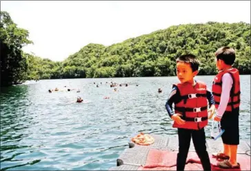  ?? SEBASTIEN BLANC/AFP ?? Chinese tourists swim in the world renowned “Jellyfish lake”, a marine lake where visitors can swim with thousands of golden jellyfish on the Rock Islands in Palau.