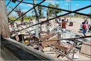  ?? TSVANGIRAY­I MUKWAZHI/AP PHOTO ?? Schoolchil­dren pick up books that were left to dry in the sun after their school was damaged by Cyclone Idai, in Inchope, Mozambique, on Monday.