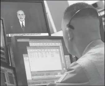  ?? ASSOCIATED PRESS ?? A trader watches Fed Chairman Ben Bernanke on a screen in his booth on the floor of the New York Stock Exchange. The Federal Reserve hinted that it’s moving closer to slowing its bond-buying program, which is intended to keep long-term interest rates...