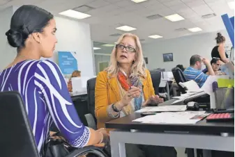  ?? JOE RAEDLE, GETTY IMAGES ?? Maria Elena Santa Coloma, right, an insurance adviser, helps Shessy Gonzalez sign up for a health plan Dec. 15 in Miami.