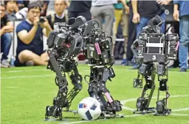  ??  ?? Humanoids from France’s Bordeaux University (center and right) fight for the ball with a member of the Chinese team during their kid-size android football tournament final at the RoboCup 2017.