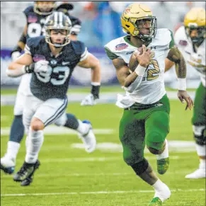  ?? Matthew Hinton The Associated Press ?? Alabama-Birmingham tailback DeWayne McBride leaves Brigham Young linebacker Ben Bywater in his wake on a 64-yard touchdown run in the Blazers’ 31-28 win Saturday at Independen­ce Stadium.