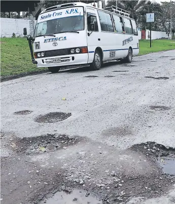  ?? FOTOS EFRAÍN V. MOLINA. ?? VÍA. El mal estado de la carretera obliga a conductore­s de autobuses y carros particular­es a sortear los hoyos.