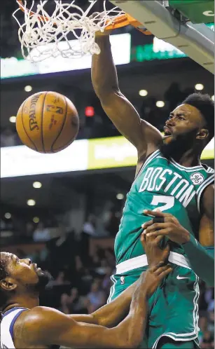  ?? MICHAEL DWYER — ASSOCIATED PRESS PHOTOS ?? Boston Celtics’ Jaylen Brown throws one down over the Golden State Warriors’ Kevin Durant during the first quarter in Boston. The Warriors stumbled in the fourth quarter to lose a close one.