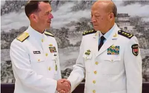 ??  ?? Gambar atas dikeluarka­n agensi Xinhua menunjukka­n jet pengebom China H6-K mengawal pulau dan terumbu di Laut China Selatan. Gambar bawah, Richardson berjabat tangan dengan Wu ketika kunjungan ke China sejak Ahad lalu.