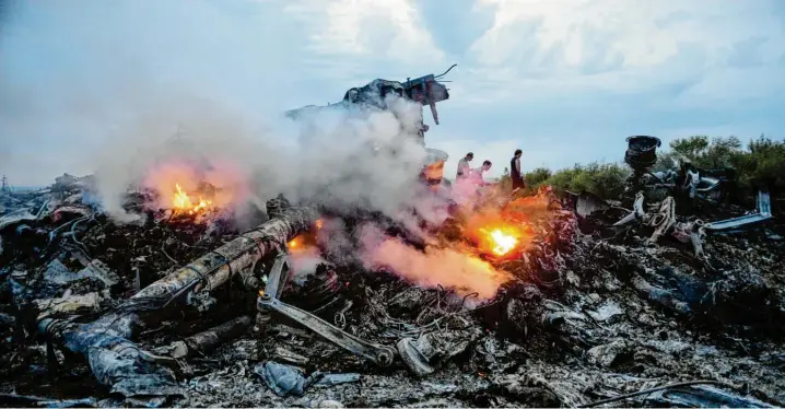  ?? Archivfoto: Alyona Zykina, dpa ?? Ein Bild des Schreckens: Trümmer der Boeing 777, die im Juli 2014 über der Ukraine abgeschoss­en wurde, stehen in Flammen.