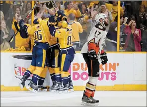  ?? AP/MARK HUMPHREY ?? Anaheim Ducks center Ryan Kesler skates past as Nashville Predators players celebrate an empty-net goal in the third period of Game 6 of the NHL Western Conference finals Monday night. Nashville won 6-3 to clinch the series and advance to the Stanley...