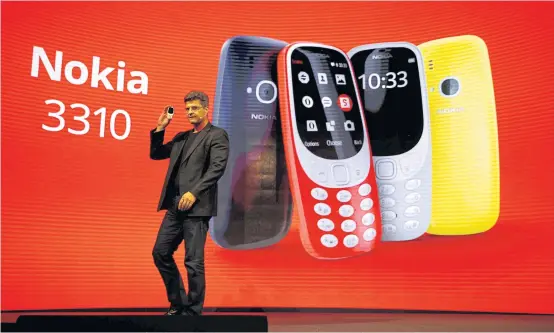  ??  ?? Arto Nummela, CEO of HMD Global Oy, holds up Nokia 3310 device during a presentati­on ceremony at the Mobile World Congress in Barcelona on Sunday.