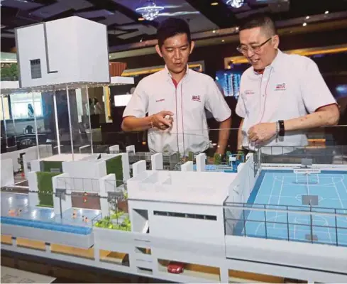  ?? PIC BY EIZAIRI SHAMSUDIN ?? UEM Sunrise Bhd chief marketing officer Kenny Wong (right) and project director for Central 2 Liong Kok Kit with a scale model of Astrea Mont Kiara in Kuala Lumpur yesterday.