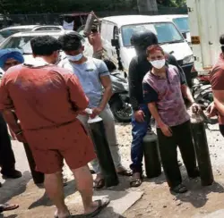  ??  ?? A QUEUE TO REFILL OXYGEN in cylinders in New Delhi on April 23.