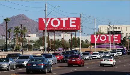  ?? (Reuters) ?? BILLBOARDS CALL on people to vote in Arizona before this week’s midterms.