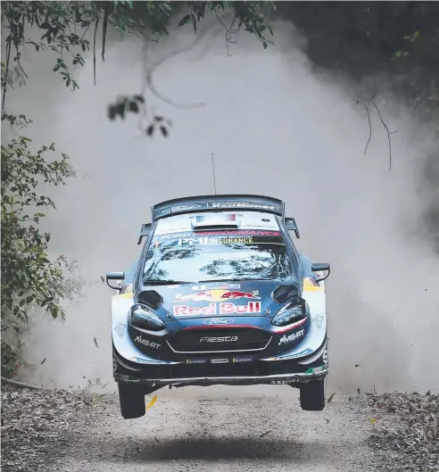  ??  ?? UP IN THE AIR: Ford driver Sebastien Ogier of France speeds over a brow on the first day of the World Rally Championsh­ip (WRC) Rally Australia near Coffs Harbour. Picture: AFP