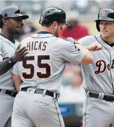  ?? HANNAH FOSLIEN/GETTY IMAGES ?? The Tigers’ Justin Upton, left, and Jim Adduci congratula­te John Hicks on his homer against the Twins Sunday.