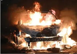  ?? ?? Ablaze: Cars were torched in scenes of violence on Monday