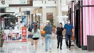  ?? DAVID J. PHILLIP/AP ?? Some shoppers wear masks as they walk through The Woodlands Mall on Tuesday in The Woodlands, Texas.