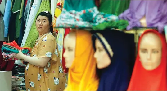  ?? AHMAD KHUSAINI/ JAWA POS ?? KEBERAGAMA­N: Dewi Lindawati, salah seorang pedagang keturunan Tionghoa di Pasang Bong. Dia berdagang perlengkap­an dan pakaian muslim. Pelanggann­ya pun sampai luar pulau.