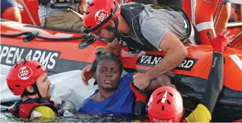  ??  ?? Pulled to safety: Rescuers lift her onto the Spanish rescue organisati­on’s boat