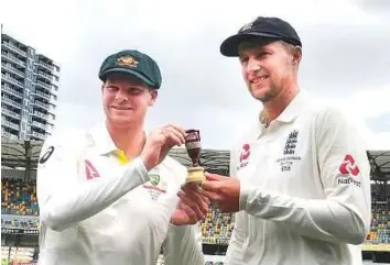  ?? AP ?? Australian captain Steven Smith (left) and his England counterpar­t Joe Root hold a replica Ashes trophy ahead of the start of the five-Test series in Brisbane yesterday.