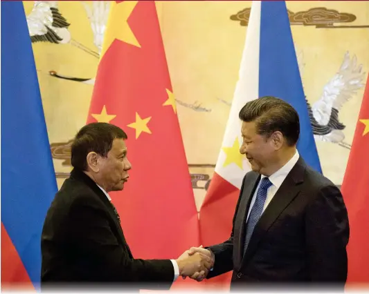  ?? Photo: AFP ?? Chinese President Xi Jinping and his Philippine counterpar­t Rodrigo Duterte shake hands after a signing ceremony in Beijing on Thursday.