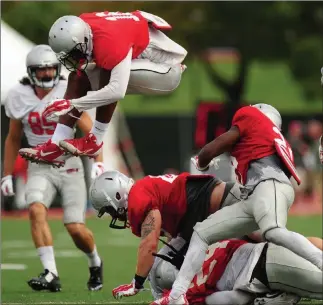  ??  ?? Las Vegas Review-journal file UNLV safety Javin White jumps over a pile of tackled players during a 2016 scrimmage.