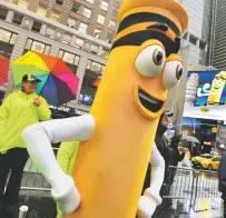  ?? RICHARD DREW/THE ASSOCIATED PRESS ?? A dandelion crayon character poses for photos Friday — National Crayon Days — during a Crayola event in New York’s Times Square. Crayola announced that it’s replacing the color dandelion in its 24-pack with a crayon in ‘the blue family.’