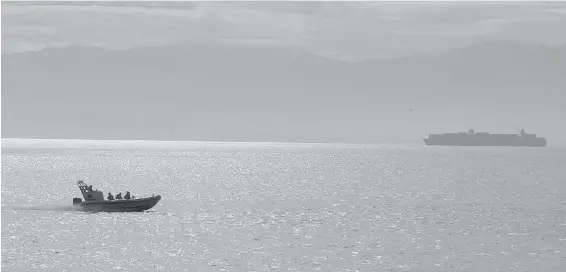  ??  ?? A whale-watching boat travels past Clover Point as a freighter traverses the Juan de Fuca Strait. Behind, the Olympic Mountains are partially obscured by filtered sunlight. After a spate of showery days, lots of sunshine is in the forecast through the...