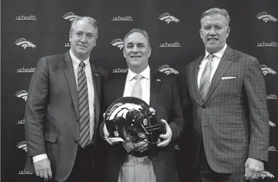  ??  ?? From left, Broncos president and CEO Joe Ellis, newly hired head coach Vic Fangio and general manager John Elway pose for photos during Thursday’s news conference.