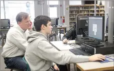  ?? LYNN KUTTER ENTERPRISE-LEADER ?? Greg Richards with Del Monte in Rogers looks over a website with Seth Swain, a sophomore at Farmington High School. Richards leads the career mentoring group for business management at the high school.