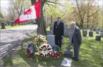  ?? CHRIS YOUNG, THE CANADIAN PRESS ?? Rev. Harold Steven, right, and his son stand at the grave of their relative, Ian Hector Steven, a Scottish soldier who died in Canada after the First World War, in St. John’s Norway Cemetery, Toronto, on Sunday.