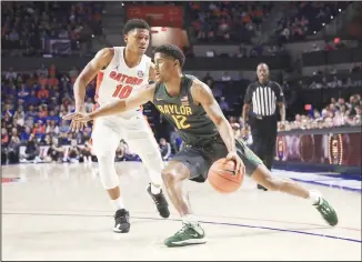  ?? (AP) ?? Baylor guard Jared Butler (12) drives around Florida guard Noah Locke (10) during the second half of an NCAA
college basketball game on Jan 25 in Gainesvill­e, Florida.