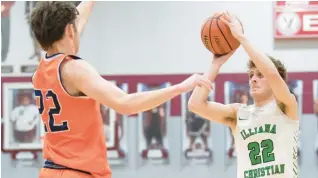  ?? KYLE TELECHAN/FOR THE POST-TRIBUNE ?? Illiana Christian guard Isaac Sherwood lines up a shot past North Newton guard Patrick Barry during the first round of the Class 2A Bowman Sectional on Wednesday.