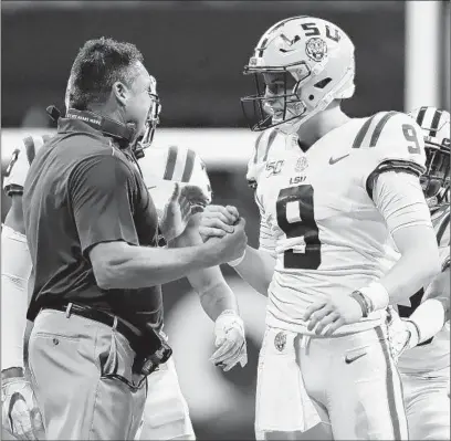  ?? KEVIN C. COX/GETTY-AFP ?? LSU coach Ed Orgeron talks with QB Joe Burrow during the Tigers’ victory over Georgia in the SEC championsh­ip game Saturday.