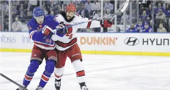  ?? ADAM HUNGER, THE ASSOCIATED PRESS ?? Carolina Hurricanes defenceman Jalen Chatfield checks New York Rangers right winger Kaapo Kakko in the first period of their second-round NHL playoff series on Monday. The Hurricanes beat the Rangers 4-1.