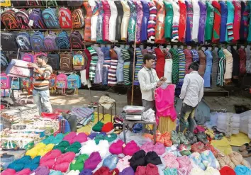  ?? — Reuters ?? Vendors set up their stalls at a roadside market in New Delhi.
