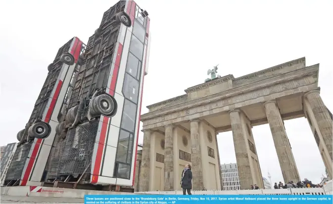  ??  ?? Three busses are positioned close to the ‘Brandeburg Gate’ in Berlin, Germany, Friday, Nov 10, 2017. Syrian artist Manaf Halbouni placed the three buses upright in the German capital, to remind on the suffering of civilians in the Syrian city of...