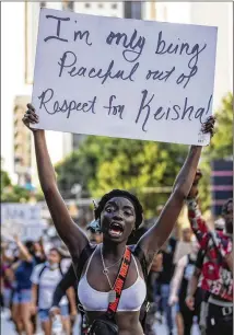  ?? ALYSSA POINTER / ALYSSA.POINTER@AJC.COM ?? A woman chants as she holds a sign referring to her peaceful protest out of respect for Atlanta Mayor Keisha Lance Bottoms during a march down Spring Street NW on May 31.