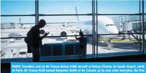  ?? — AFP ?? PARIS: Travellers and an Air France Airbus A380 aircraft at Roissy-Charles de Gaulle Airport, north of Paris. Air France-KLM named Benjamin Smith of Air Canada as its new chief executive, the first non-French head of the group despite resistance from its powerful trade union.