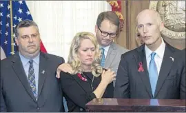  ?? Mark Wallheiser Associated Press ?? FLORIDA GOV. RICK SCOTT, right, with parents of students killed in the Parkland, Fla., shooting. From left, Tony Montalto and wife Jennifer, parents of victim Gina Montalto, 14; and Ryan Petty, father of victim Alaina Petty, 14.