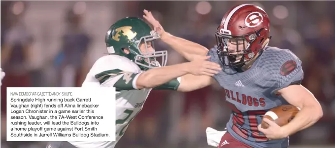  ?? NWA DEMOCRAT-GAZETTE/ANDY SHUPE ?? Springdale High running back Garrett Vaughan (right) fends off Alma linebacker Logan Chronister in a game earlier this season. Vaughan, the 7A-West Conference rushing leader, will lead the Bulldogs into a home playoff game against Fort Smith Southside in Jarrell Williams Bulldog Stadium.