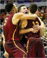  ?? RONALD MARTINEZ / GETTY IMAGES ?? Loyola’s Clayton Custer (right) is mobbed by teammates after hitting the winning shot against the Vols on Saturday.