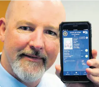  ?? AP ?? Ryan Williams, with the Utah Drivers License Division, displays his cell phone with the pilot version of the state’s mobile ID on Wednesday, May 5, 2021, in West Valley City, Utah.