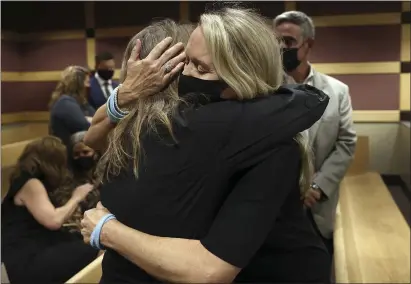  ?? PHOTOS BY AMY BETH BENNETT — SOUTH FLORIDA SUN SENTINEL ?? Gena Hoyer, right, hugs Debbi Hixon during a court recess Wednesday at the Broward County Courthouse in Fort Lauderdale, Fla. Hoyer’s son, Luke Hoyer, 15, and Hixon’s husband, Christophe­r Hixon, 49, were both killed in the massacre.
