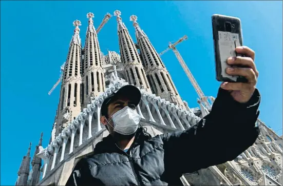  ?? LLUIS GENE / AFP ?? Selfie a cara tapada. Un turista con mascarilla se
fotografía ayer ante la Sagrada Família, que ha reducido su aforo a 1.000
personas