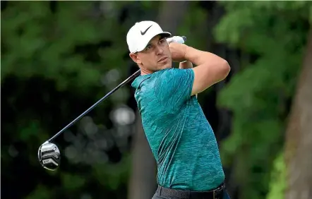  ?? GETTY IMAGES, AP ?? Brooks Koepka pounds his ball down the middle of the fairway on the 17th at Bellerive on Monday to hold off the challenge from Tiger Woods, below, and win the PGA Championsh­ip by two strokes.